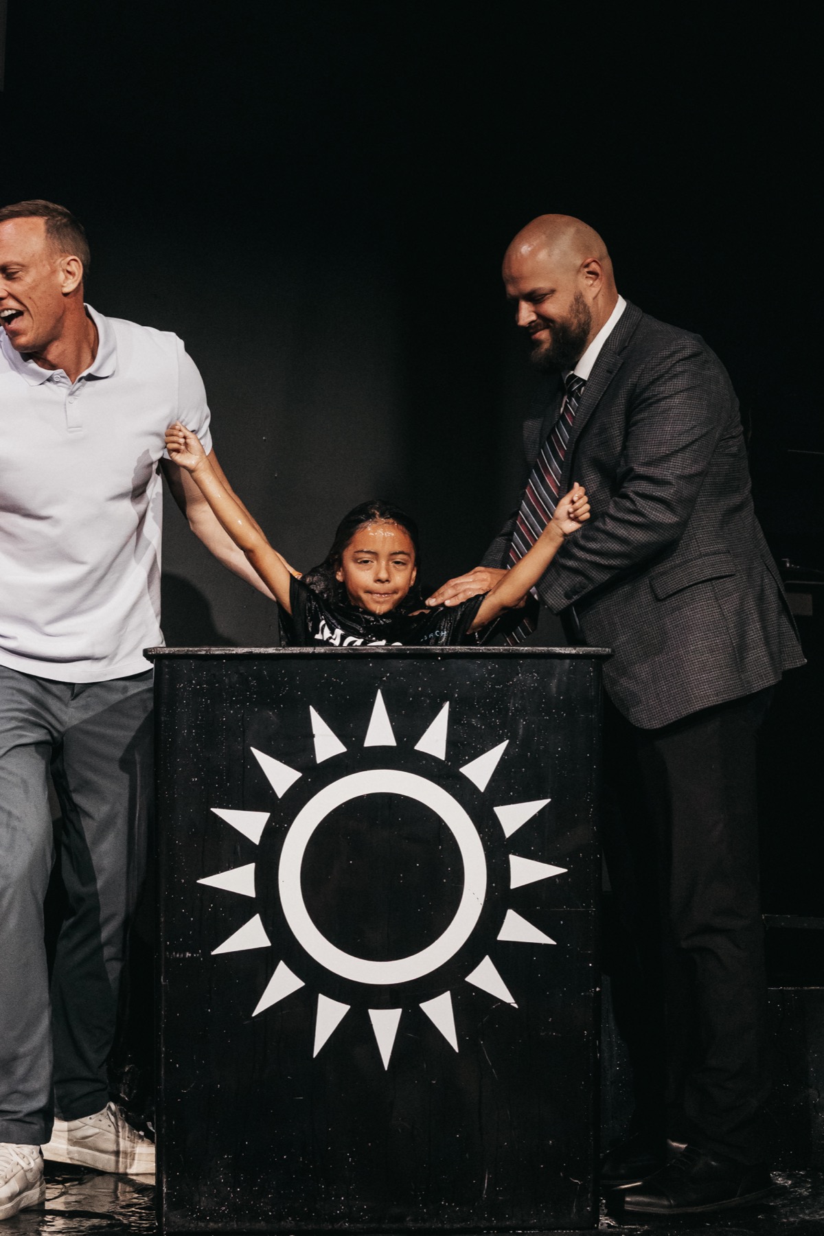 A couple stands in front of a Made New baptism banner.